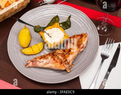 Roast rabbit served with potatoes and braised peppers Stock Photo
