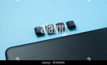 Fail word made from keyboard keys on a laptop corner with blue background, representing failure, mistake, pressure, setback, and business challenge. Stock Photo