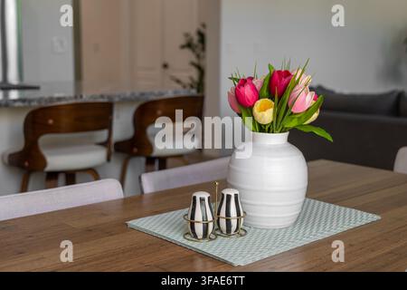 Modern home interior with a colorful floral dining room table centerpiece Stock Photo