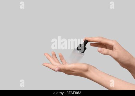 Skincare and beauty product application, womans hands holding a dropper bottle with serum or oil, cosmetic routine and self-care Stock Photo