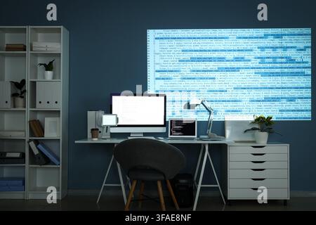 Software development and coding at night, programmer working late with multiple screens and projected code on wall Stock Photo