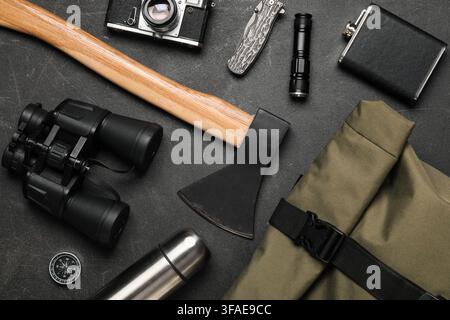 Outdoor adventure and camping gear, flat lay of essential equipment for hiking and exploration on a dark background Stock Photo