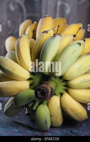 Bananas arranged in a bunch on a blue table surface Stock Photo