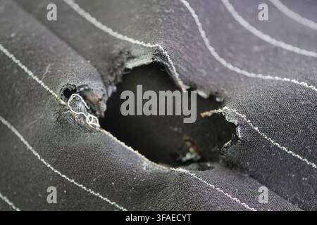 Hole in fabric shows wear and tear from regular use Stock Photo