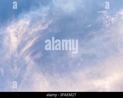 A serene sky filled with soft, pastel clouds in shades of blue and pink. The clouds create a calming atmosphere, ideal for backgrounds or nature theme Stock Photo