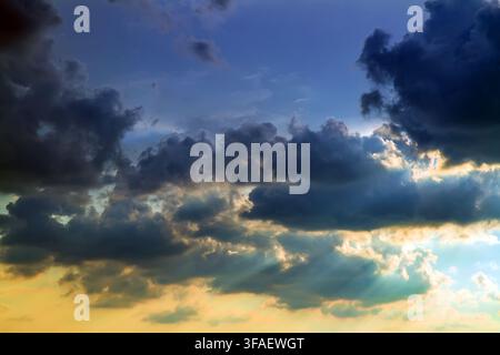 Dramatic sky at sunset. Dark cumulus clouds. Stock Photo