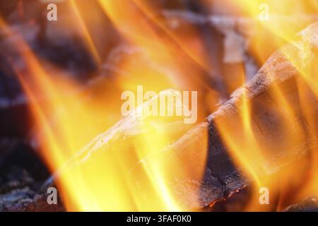 Glowing embers in hot red color, abstract background. The Hot Embers of Burning Wood Log Fire. Firewood burning on grill. Texture Fire Bonfire Embers Stock Photo