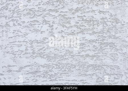 Textured white wall with subtle patterns and variations. The surface appears rough and uneven, creating an interesting visual effect Stock Photo