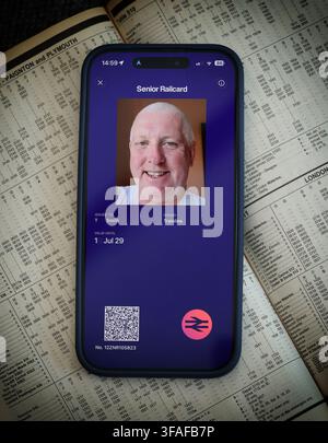 Senior digital Railcard displayed on a smartphone over a railway map, showing the three-year UK discount card for older train passengers. Stock Photo