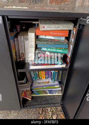 Books inside the Wright's Green community book share at Appleton Thorn, a free local mini-library supported by the parish community. Stock Photo