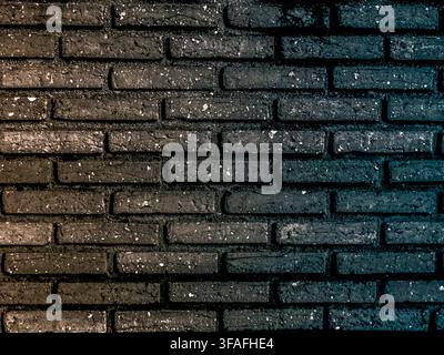 High-resolution texture of a dark brick wall featuring a creative lighting split, blending warm golden tones on the left with cool cyan and blue highl Stock Photo