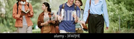 Header of Diverse Students with Books Using Smartphone While Walking on Campus Stock Photo