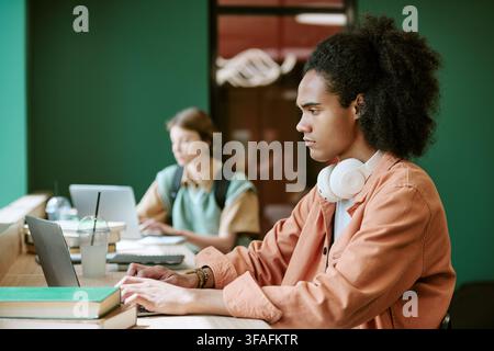 Diverse Students Studying on Laptops in University Campus Library Stock Photo