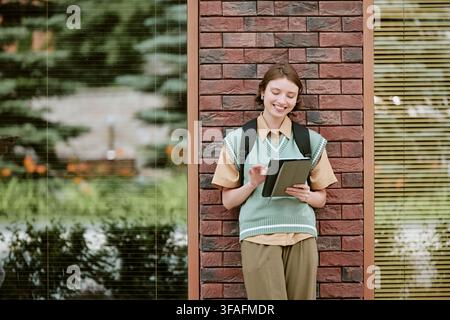Happy Woman Student Using Digital Tablet on University Campus Stock Photo
