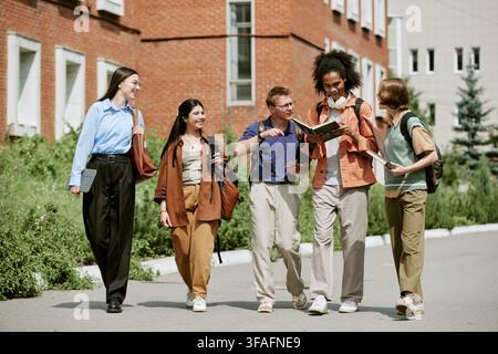 Diverse Group of Students Walking on Campus and Studying Together Stock Photo
