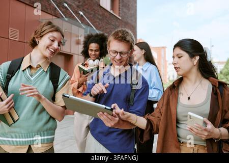 Diverse Group of Students Using Digital Tablet on University Campus Stock Photo