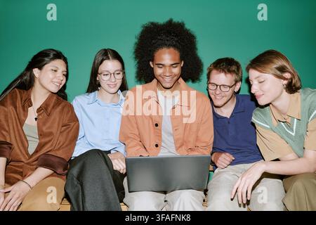 Diverse Group of Students Studying Together on Laptop in Campus Stock Photo