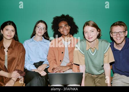 Portrait of Diverse Group of Students Sitting with Laptop on Campus Stock Photo