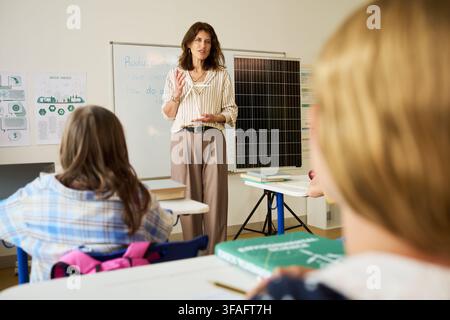 Middle Aged Woman Teaching Environmental Science to Teenagers in Classroom Stock Photo