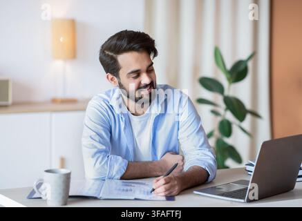 Successful Eastern Entrepreneur Working With Documents And Laptop At Home Office Stock Photo