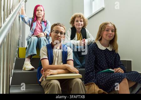 Portrait of Diverse Group of School Children Sitting on Stairs Stock Photo