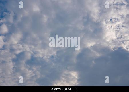 Clear vibrant blue sky decorated with big soft white cumulus cloud and faint wispy cloud streaks on sunny day. Stock Photo