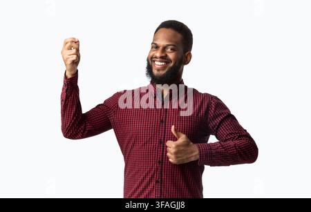 Cheerful African Guy Gesturing Thumbs-Up Approving Taste Over White Background Stock Photo