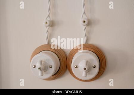 A close-up view of wall-mounted light switches in an indoor residential or commercial space, showcasing a neutral and functional design. The switches Stock Photo