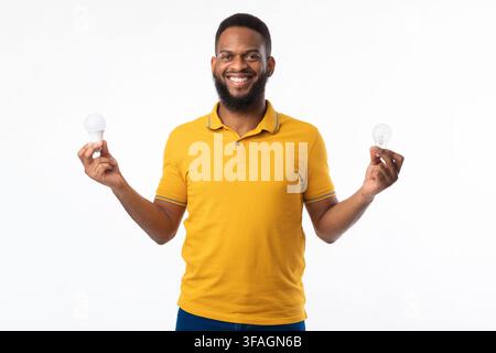 African American Guy Holding Light Bulbs Standing On White Background Stock Photo