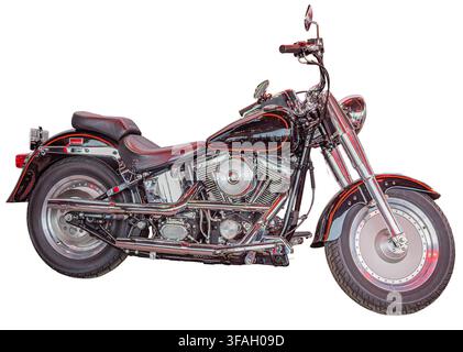 Classic cruiser motorcycle isolated on white background, showcasing polished chrome finish, black paint job, dark brown leather seat, V-twin engine, m Stock Photo