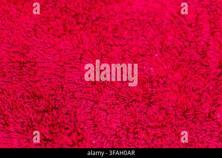 Closeup of a bright red fluffy carpet surface filling the entire frame. Stock Photo