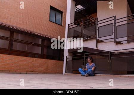Female Reader Accessing Digital Content on Tablet in Urban Residential Setting Stock Photo