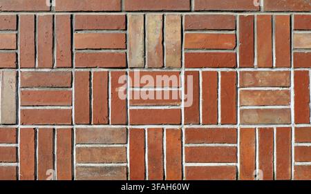 Old tiled wall made of earthenware tiles arranged geometrically. Colors are different shades of brown. Full frame, background and texture. Stock Photo