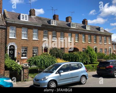 Row of 18th century grade II listed terraced houses in the village on a sunny day Stock Photo
