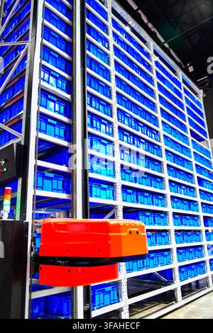 Automated storage and retrieval system with robotic arm in modern warehouse facility Stock Photo
