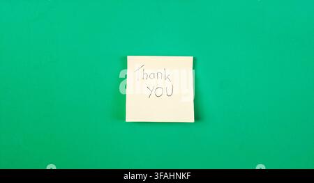 Handwritten Thank You Message on Sticky Note with Green Background Stock Photo