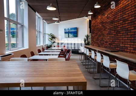 Modern office cafeteria interior with brick wall and wooden ceiling Stock Photo
