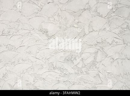 Close up of a tan stucco wall surface with coarse gritty texture, thick applied stucco, loose decorative trowel swirls Stock Photo