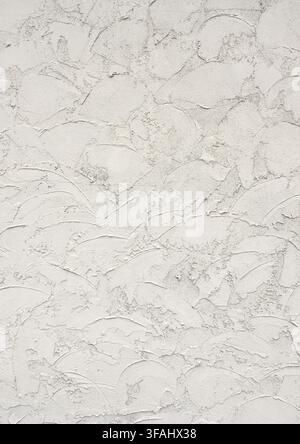 Close-up of a buff stucco wall surface with coarse gritty thick applied stucco, loose decorative trowel swirls in various sizes Stock Photo