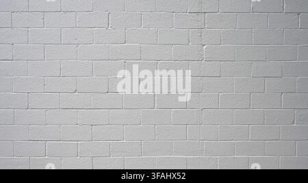 Horizontal view of painted white cinder block wall surface with flat concrete texture, porous, rough cinderblocks Stock Photo