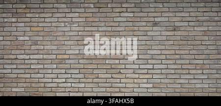 Horizontal view of variegated brown brick and mortar wall surface with porous, uneven bricks, and darker brown mortar joints Stock Photo