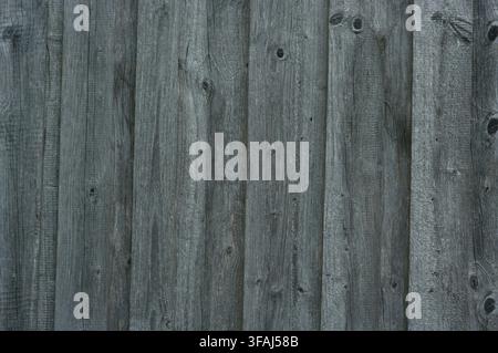 Bavaria, Germany - January 1, 2008: Weathered gray wooden fence with vertical planks and rustic knots creating a textured, neutral background suitable Stock Photo