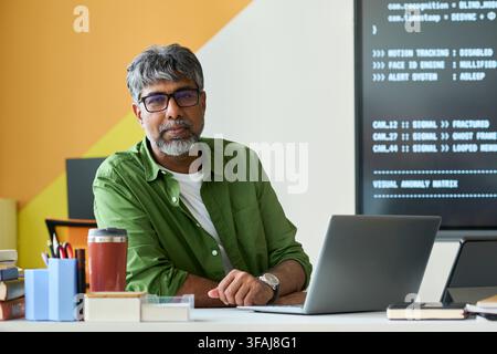 Portrait of Indian Middle Aged it Specialist Working on Laptop Stock Photo
