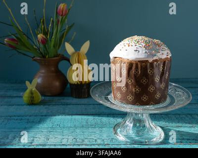 Traditional Easter Paska also known as Pasca presented on a glass cake stand surrounded by spring decorations creating a festive holiday table setting Stock Photo