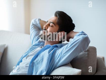 Relax Time. Handsome Arab Man Leaning Back On Couch With Closed Eyes Stock Photo