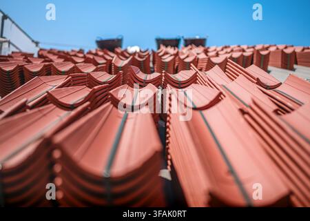 Stacks of red clay roof tiles under blue sky Stock Photo