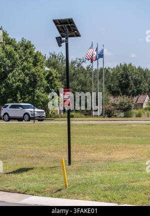 Georgetown, TX - August 20 2026: A Flock Safety license plate reader camera system with a solar panel operates on a suburban street pole. Stock Photo