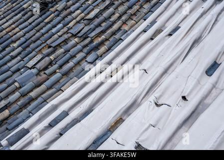 Dark gray terracotta tiles and corrugated white material on the roof Stock Photo