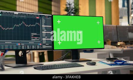 Green screen PC displaying stock market graphs in proprietary firm office. Chroma key PC on brokerage workspace desk used for stock exchange analysis and strategy planning Stock Photo