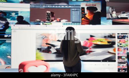 Woman enters world of online media, enjoying access to digital platform delivering videos on demand. African american person looking at dashboard featuring lifestyle and entertainment clips, camera A Stock Photo